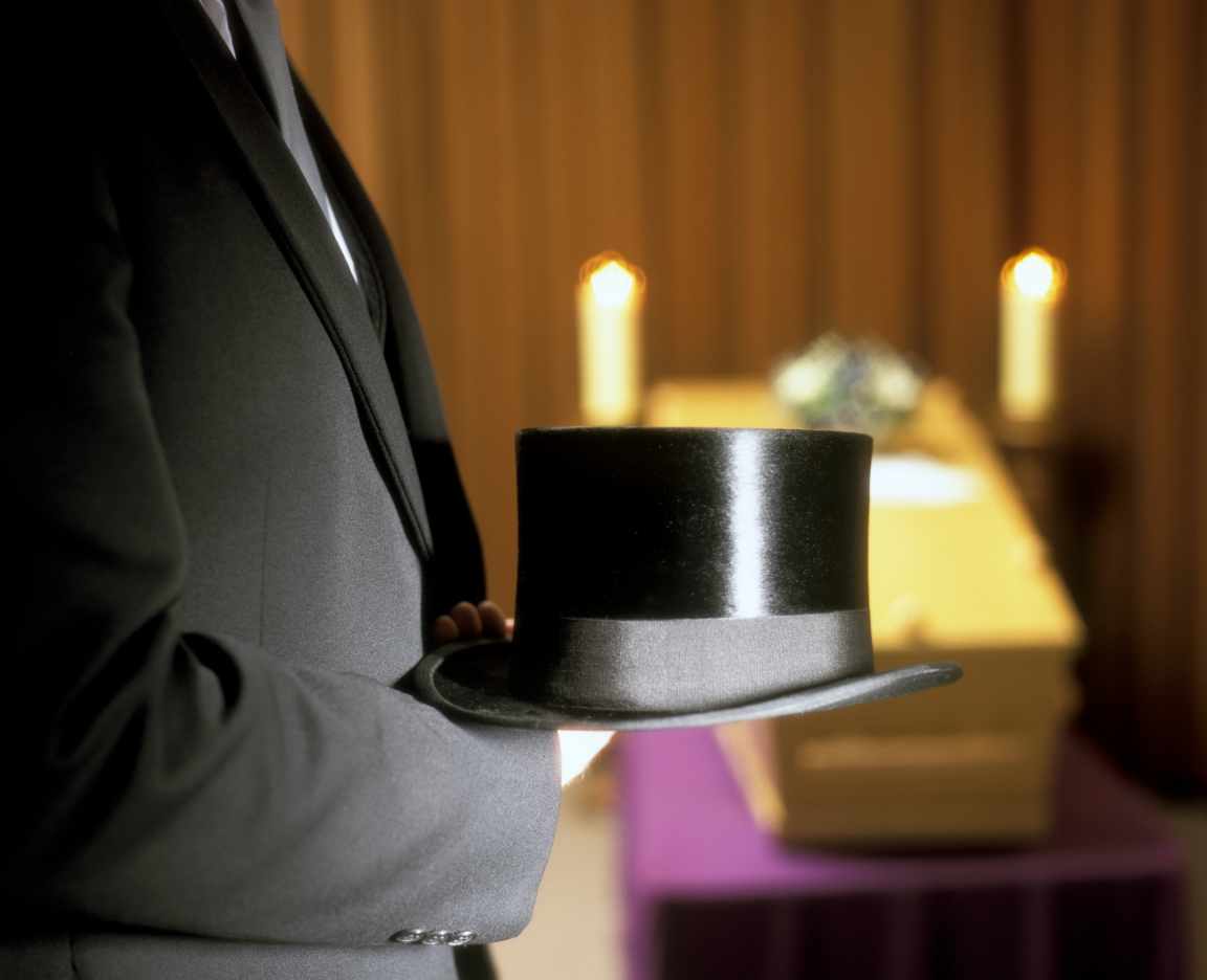 Mann im Anzug mit Zylinder in der Hand